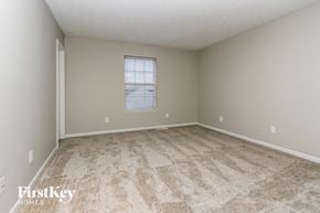 Indianapolis house for rent - a spacious bedroom with carpeted flooring and a window
