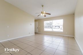 Kissimmee house for rent - a spacious living room with tiled flooring and a ceiling fan