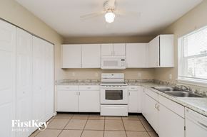 Kissimmee house for rent - a kitchen with white cabinets and white appliances and a sink