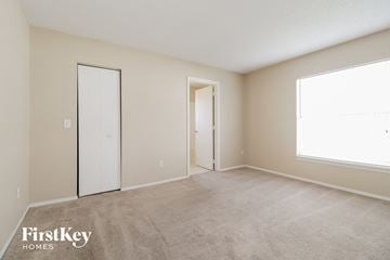 Kissimmee house for rent - a spacious living room with carpet and a door to a closet