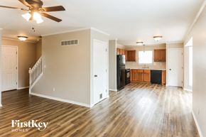 Wentzville house for rent - an empty living room and kitchen with a ceiling fan