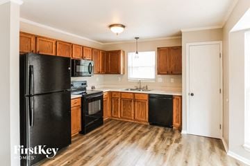 Wentzville house for rent - a kitchen with black appliances and wooden cabinets