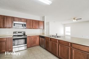 Poinciana house for rent - an empty kitchen with wooden cabinets and stainless steel appliances