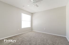 Poinciana house for rent - a spacious room with carpet and a ceiling fan