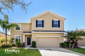 Ruskin house for rent - a beige house with a garage door and palm trees