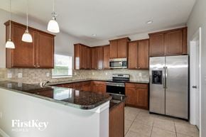 Ruskin house for rent - a kitchen with wooden cabinets and granite counter tops and stainless steel appliances