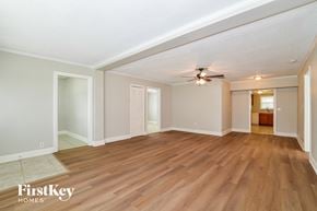 Apopka house for rent - A spacious room with wooden flooring and a ceiling fan.