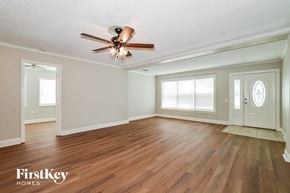 Apopka house for rent - A room with a ceiling fan and wooden floors.