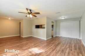 Casselberry house for rent - the living room and dining room with wood flooring and a ceiling fan