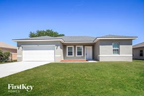 Poinciana house for rent - a white house with a lawn in front of it