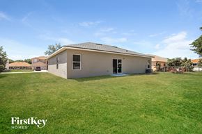 Poinciana house for rent - the backyard of a house with a yard and grass