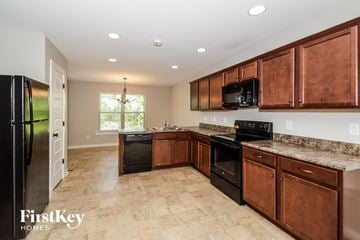 Odenville house for rent - a kitchen with wooden cabinets and black appliances