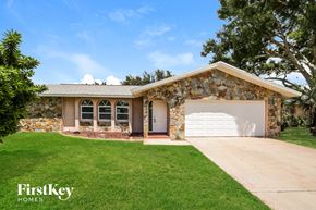 Cape Coral house for rent - A house with a stone wall and a garage door.