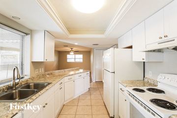 Cape Coral house for rent - A kitchen with white cabinets and a stove top oven.