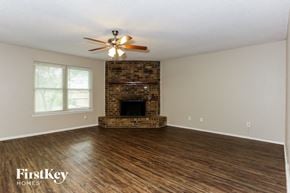 Mansfield house for rent - A spacious room with a fireplace and a ceiling fan.