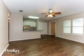 Mansfield house for rent - A spacious room with a ceiling fan and wooden flooring.