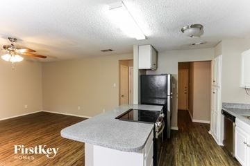 Mansfield house for rent - A kitchen with a black stove top oven and a fan on the ceiling.