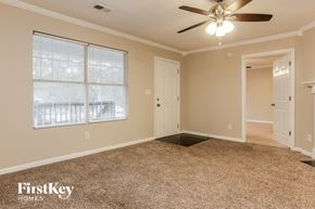 Atlanta house for rent - A room with a carpeted floor, a ceiling fan, and a window with blinds.