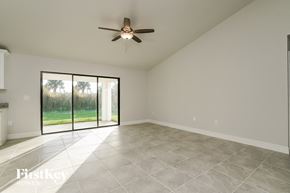 Lehigh Acres house for rent - A spacious room with a ceiling fan and sliding glass doors.