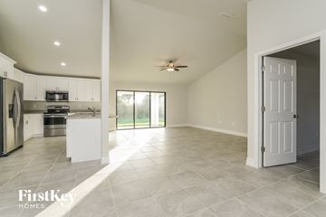 Lehigh Acres house for rent - A spacious kitchen and living room with a sliding glass door leading to a backyard.