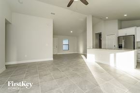 Lehigh Acres house for rent - A spacious, empty room with a fan and a window.