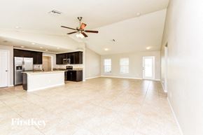 Cape Coral house for rent - an empty kitchen and living room with a ceiling fan