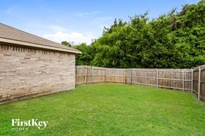 Lancaster house for rent - A backyard with a wooden fence and a brick building.
