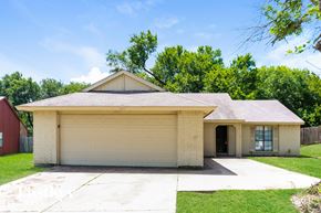 Desoto house for rent - A two-car garage with a brick exterior and a gabled roof.