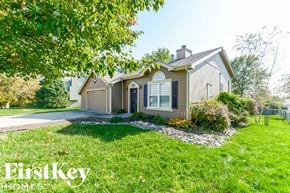 Raymore house for rent - A house with a well-kept lawn and a tree branch in the foreground.