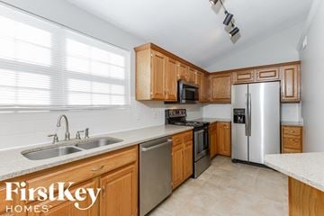 Raymore house for rent - A kitchen with wooden cabinets and stainless steel appliances.
