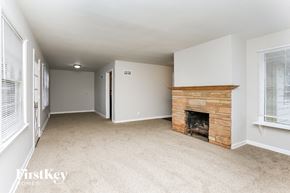 Waukegan house for rent - A living room with a fireplace and carpeted floor.