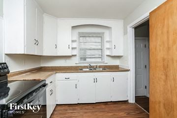 Waukegan house for rent - A kitchen with white cabinets and a wooden floor.