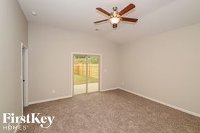 Leeds house for rent - A room with a ceiling fan and a sliding glass door leading to a backyard.