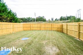 Leeds house for rent - A backyard with a wooden fence and a grassy area.