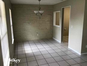 Casselberry house for rent - a living room with a tile floor and a brick wall