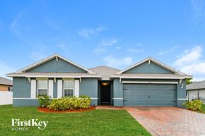 Cape Coral house for rent - a blue house with green grass and a blue sky