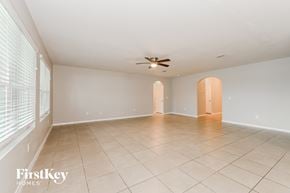 Cape Coral house for rent - an empty living room with a ceiling fan and a large window