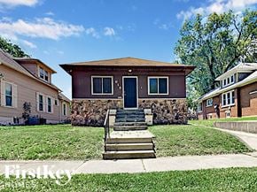 Joliet house for rent - a small brown house with stairs in front of a yard