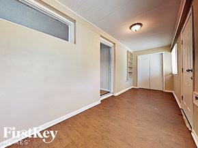 Joliet house for rent - a hallway with wood floors and white walls and a door to a closet
