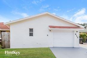 Lake Worth house for rent - A white house with a red roof and a garage door that says 617.