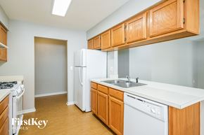 Winter Haven house for rent - a kitchen with white appliances and wooden cabinets