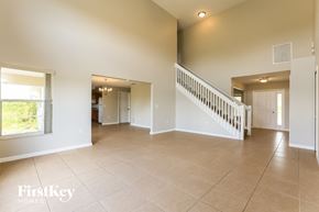Lehigh Acres house for rent - A spacious living room with a staircase leading to the upper floor.