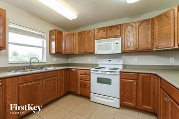 Lehigh Acres house for rent - A kitchen with wooden cabinets and a white stove top oven.