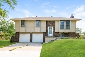 Excelsior Springs house for rent - a tan house with two garage doors and a lawn