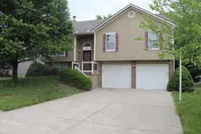 Raymore house for rent - A two-car garage is attached to a house.