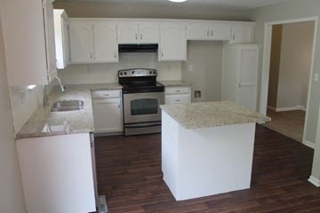 Raymore house for rent - A kitchen with white cabinets and a granite counter.