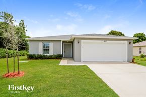 Port St. Lucie house for rent - a white house with a lawn and a driveway