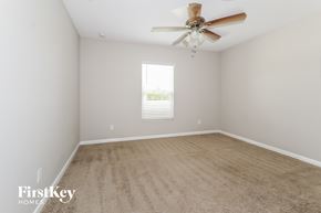 Port St. Lucie house for rent - a spacious room with a ceiling fan and a carpet