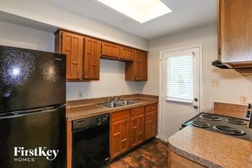Mansfield house for rent - a kitchen with black appliances and wooden cabinets