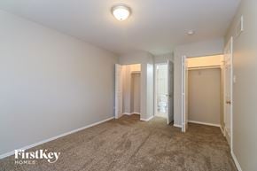 University Park house for rent - a master bedroom with a carpeted floor and a door to a bathroom